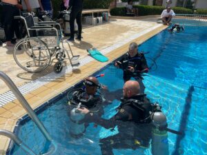 SSI Certified Diver Course - Wheelchair by the pool with instructors and divers training in the dive pool